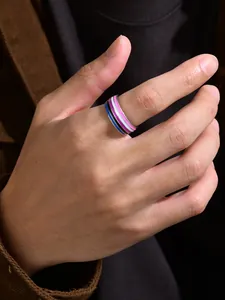Detail shot of a stylish 8mm rainbow striped enamel ring worn on a hand-model