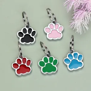 Detail view of colorful paw-shaped alloy pet tags in five vibrant enamel colors