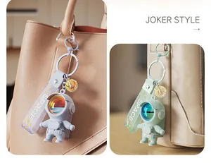 Detail view of cute astronaut keychain bag charm with reflective visor and SPACE strap