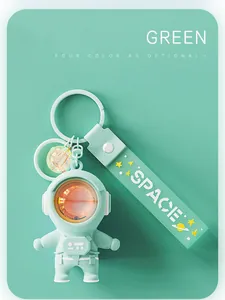 Close-up of mint green astronaut keychain with glowing sunset lamp helmet detail