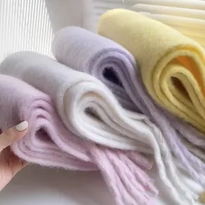 Soft macaron colored plush scarves showing thick texture and tassel details