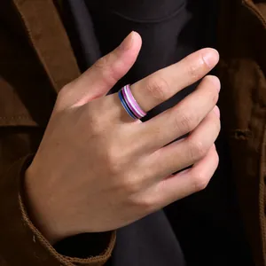 Detailed macro view of an 8mm genderfluid pride flag striped enamel ring on a hand.