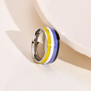 Close-up of an 8mm wide non-binary pride flag colored enamel ring in polished silver finish