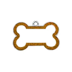 Close-up macro view of bone pet identity tag with orange glitter and silver ring