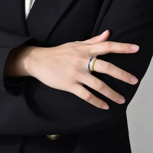 Detailed shot of an 8mm non-binary pride flag ring on a model in a black suit