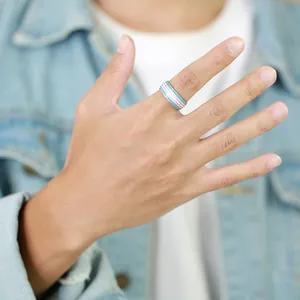 Detailed view of 8mm transgender pride flag striped ring worn on a person's hand.