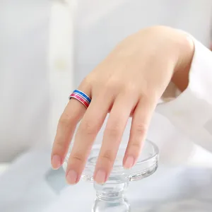 Close-up of a 8mm colorful striped stainless steel ring worn on a hand detail shot