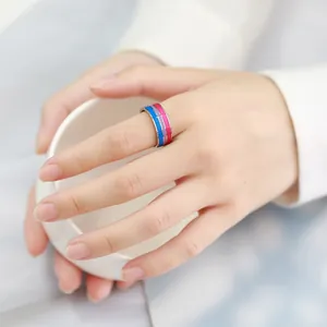 Close-up of 8mm stainless steel ring with blue purple and pink colored stripes on finger