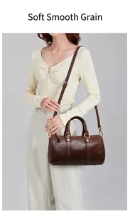 Vintage brown leather Boston handbag carried by a model with a shoulder strap