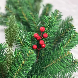 High-density green artificial Christmas garland rattan featuring vibrant red holly berries