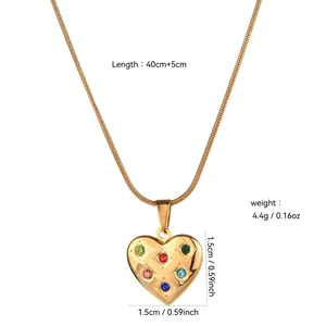 Macro view of heart-shaped gold pendant with inlaid stones and measurement details