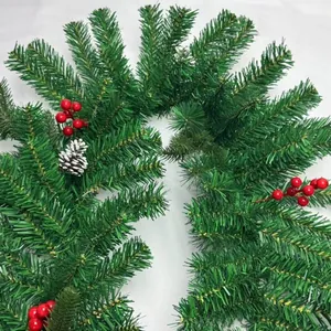 Close-up detail of dense green Christmas pine garland with red berries and pinecone