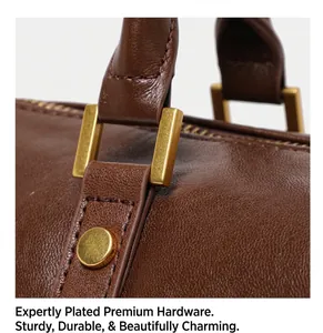 Close-up of golden hardware and textured brown leather on a retro Boston bag