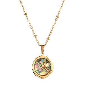 Detailed close-up of a gold stainless steel necklace with abalone shell and star pendant.