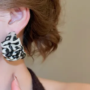 Close-up showing the elegant wearing effect of retro leopard print leather fold earrings