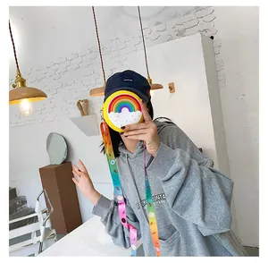 Young woman holding a cute rainbow silicone mini crossbody bag with a colorful strap