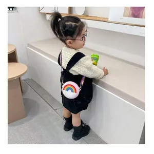 Adorable Asian toddler girl wearing a cute pink circular rainbow silicone crossbody bag