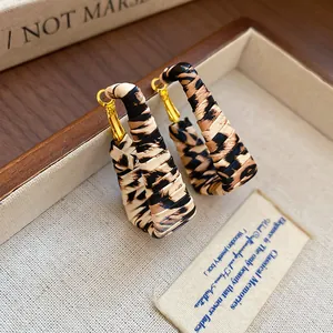 Vintage leopard print geometric leather earrings displayed in a luxury wooden jewelry box