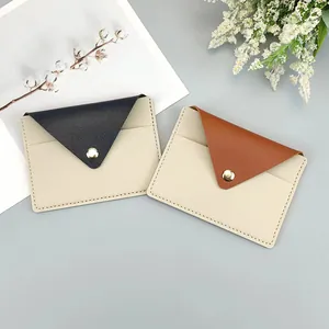 Detailed view of two slim leather card holders in beige with black and brown flaps.
