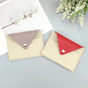 Slim minimalist envelope card holder in red and mauve faux leather with gold snap closure