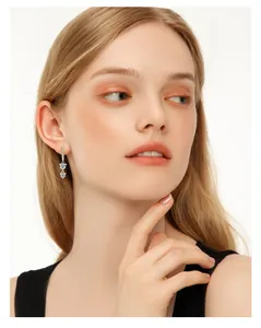 Elegant long moissanite drop earrings in 925 sterling silver shown on model face