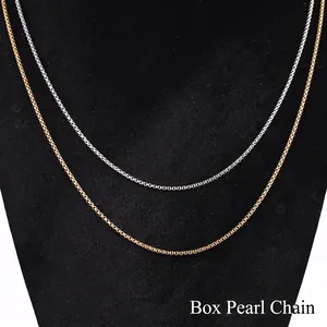 Detailed macro view of gold and silver square pearl necklaces on a black bust