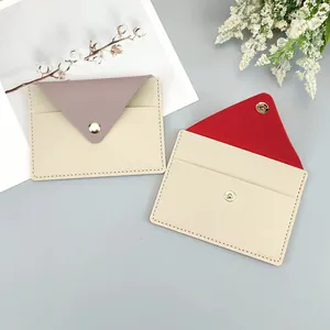 Slim envelope-style card holders in beige with pink and red color-blocked flaps.