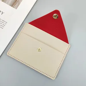 Detailed macro view of a slim envelope card holder with red lining and gold snap.