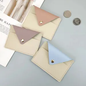 Detailed view of three pastel-colored slim leather card holders with snap buttons