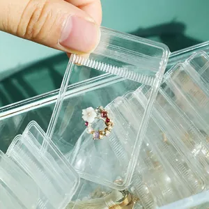 Close-up of transparent PVC self-sealing bag storing a small floral jewelry ring.