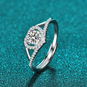 Nahaufnahme eines Moissanit-Rings mit Pavé-Steinen vor einem blaugrünen Glitzerhintergrund