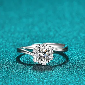 Makroansicht eines 1-Karat-Moissanit-Rings mit herzförmigen Krappen auf blauem Glitzer