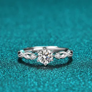 Detailansicht eines Moissanit-Rings mit Sechs-Krallen-Fassung auf petrolfarbenem Glitzer