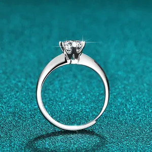 Seitenansicht eines eleganten Moissanit-Rings mit Sechs-Krallen-Fassung auf petrolfarbenem Grund