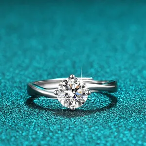Nahaufnahme eines funkelnden 1-Karat Moissanit Rings auf blauem Glitzerhintergrund