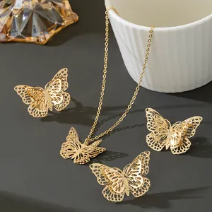 Vue détaillée d'une parure dorée en forme de papillon évidé comprenant collier et boucles.