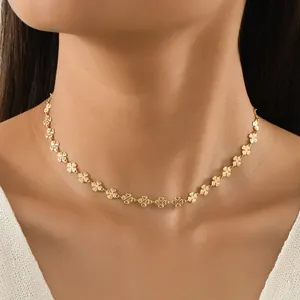 Gros plan détaillé d'un collier doré à trèfles à quatre feuilles sur le cou