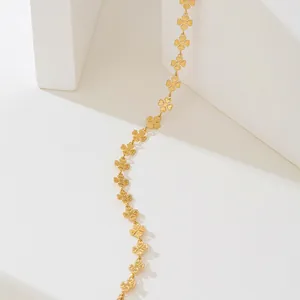 Gros plan détaillé d'un collier trèfle doré avec une superbe finition givrée