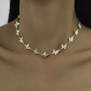 Gros plan détaillé d'un collier ras du cou papillon plaqué or porté par un mannequin.