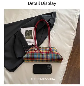 Close-up of retro plaid Boston bag shown next to a smartphone for scale comparison