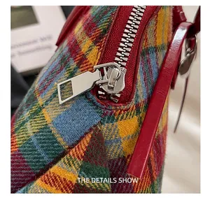 Macro detail shot showing the silver metal zipper on a colorful plaid fabric Boston bag