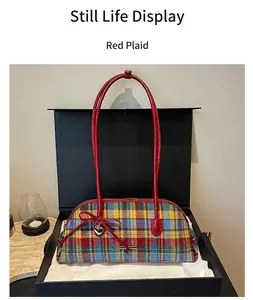 Close-up view of a retro red plaid Boston handbag presented inside a luxury black gift box.