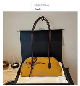 Yellow suede Boston shoulder bag with bow detail displayed in a premium black gift box