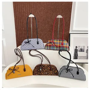 A collection of retro long-handle underarm bags displayed on a white curvy stand.