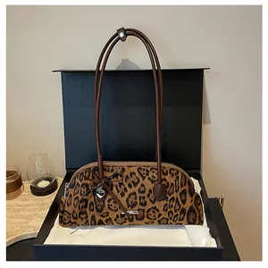Detailed view of retro leopard print handbag inside a black gift box packaging