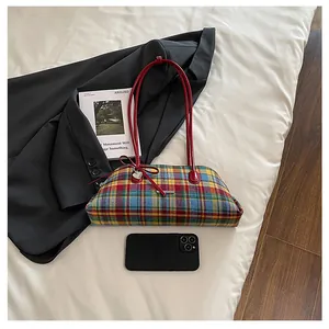 Vintage plaid underarm bag with red handles and heart charm shown with phone for scale