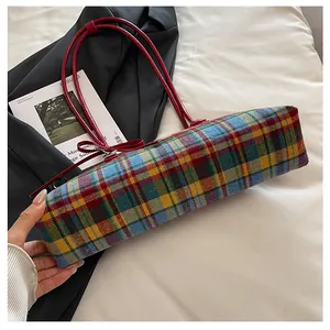 Close-up detail of a vintage colorful plaid boston shoulder bag with elegant red straps