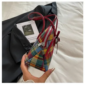 Side profile of a stylish vintage plaid boston bag featuring durable red handles.