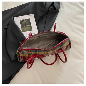 Interior view of a vintage plaid Boston bag featuring red handles and metal zipper detail