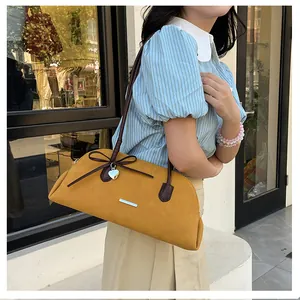 Model wearing a mustard yellow retro Boston bag with a dark brown bow detail.